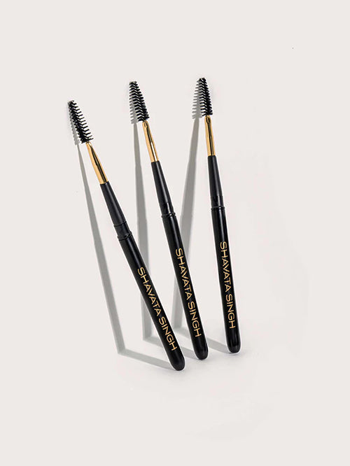 Three lash brushes with black handles and gold accents, standing upright on a white background.